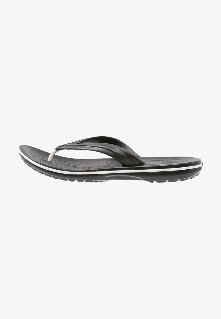 Sandale tongs noire et blanche avec semelle intérieure texturée, bride incurvée et semelle striée pour une meilleure adhérence, vue de côté.