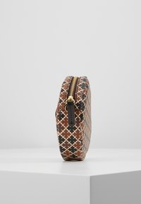 Braune, gemusterte Clutch-Tasche mit strukturierter Oberfläche, die geometrische Designs in Schwarz und Beige zeigt, goldener Reißverschluss und schlankes Profil.