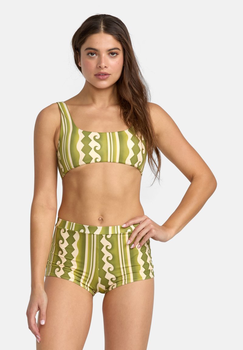 Green patterned bikini top with wide straps and matching high-waisted shorts featuring wavy and striped designs in cream and olive tones.