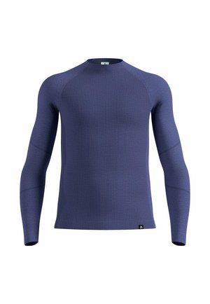 Maglia sportiva a maniche lunghe in blu scuro, realizzata in tessuto strutturato con un motivo sottile. Presenta maniche raglan e un collo rotondo.