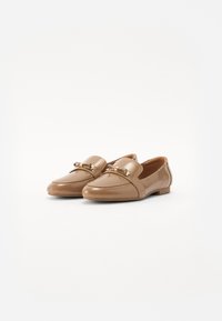 Mocassins en cuir tan avec une finition brillante, présentant un accent décoratif en métal doré et un design à bout rond plat.