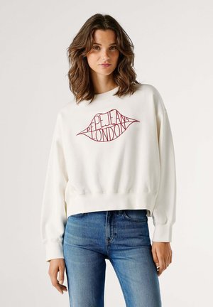 White sweatshirt with red embroidered lip graphic reading "PEPE JEANS LONDON." Features dropped shoulders and ribbed cuffs. Paired with blue jeans.