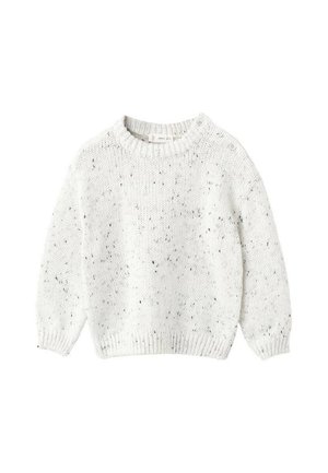 Pull en tricot blanc avec un col rond, arborant un motif texturé et de petites taches noires, accentué par des boutons sur une épaule.
