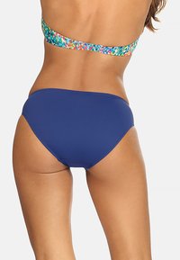 Niebieskie majtki bikini o gładkiej fakturze i pełnym kryciu, w połączeniu z kolorowym topem bandeau w wzory.