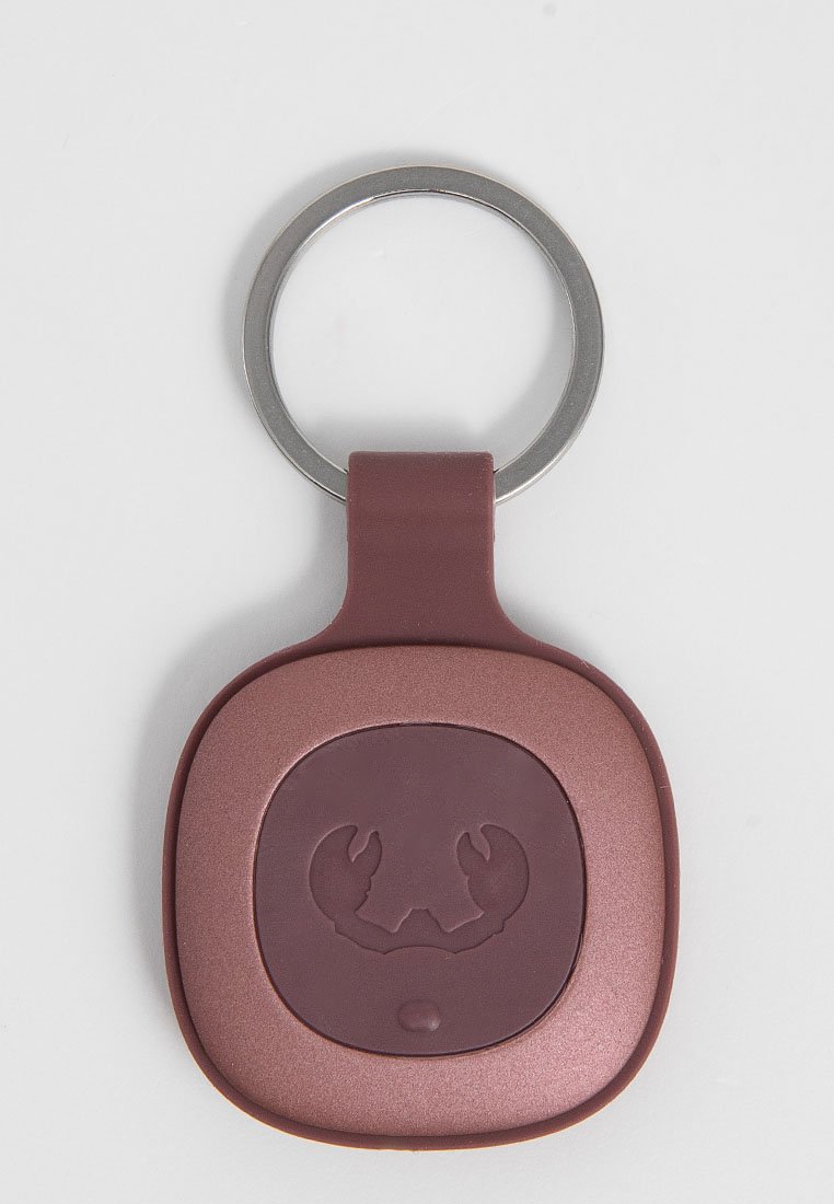 Kwadratowy, bordowy brelok z połyskującym wykończeniem, z uniesionym wzorem kraba na środku i metalowym uchwytem na klucze.