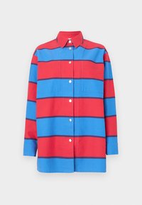 Punainen ja sininen raidallinen puuvillapaita, jossa on napitettavat edessä, kaulus ja kaksi rintataskua metallinapeilla.