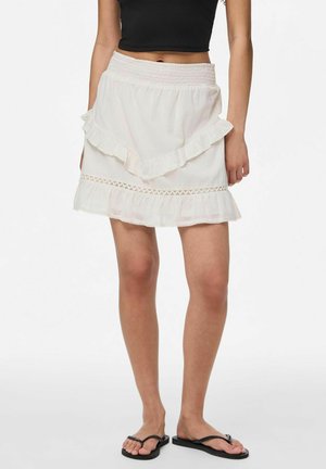 Falda blanca de volantes con bordes rizados y dobladillo de encaje decorativo. Cintura elástica para mayor comodidad, combinada con chanclas negras.