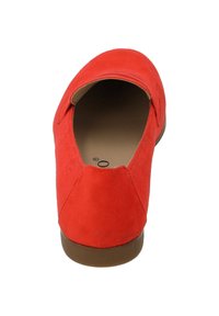 Scarpa slip-on in suede rosso con punta arrotondata e tacco basso marrone, caratterizzata da una fodera interna liscia. Design semplice senza hardware visibile.
