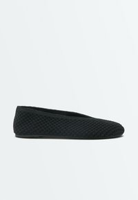 Chaussure de ballet plate noire tissée avec bout arrondi et talon bas, vue de côté sur un fond clair uni.