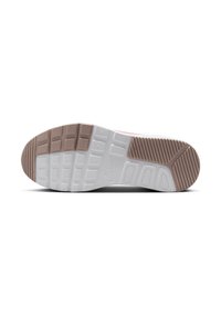 Semelle de sneaker blanche et marron clair avec une surface texturée. Présente des motifs rectangulaires et circulaires, avec une marque visible près du centre.