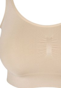 Beige sömlös bh med rundad halsringning, lätt ribbad textur och en subtil rynkad detalj i mitten. Mjuk, elastisk tyg.