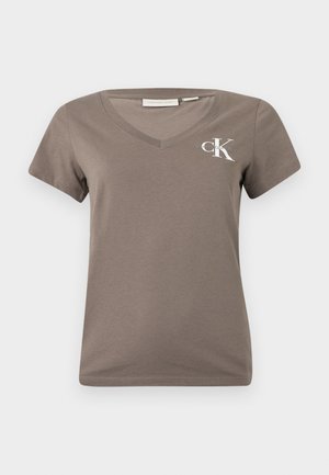 Pruun v-kaelusega t-särk, mis on valmistatud pehmest puuvillast, lühikeste varrukatega ja vasakul rinnal valge "CK" logo. Lihtne ja sobiv disain.