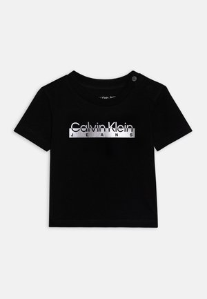 T-shirt noir à manches courtes pour tout-petit avec le logo blanc "Calvin Klein Jeans" sur le devant et des boutons-pression sur l'épaule gauche.