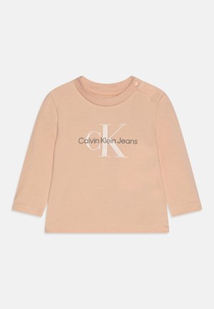 Beiges Baby-Langarmshirt mit rundem Ausschnitt, Schulter-Druckknopf und „Calvin Klein Jeans“-Logo in Weiß und Grau, mittig vorne.