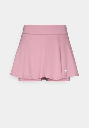 Falda deportiva rosa con un diseño acampanado, cinturilla elástica y pantalones cortos incorporados. Presenta un logotipo blanco de Nike en la parte inferior izquierda. Tela suave.