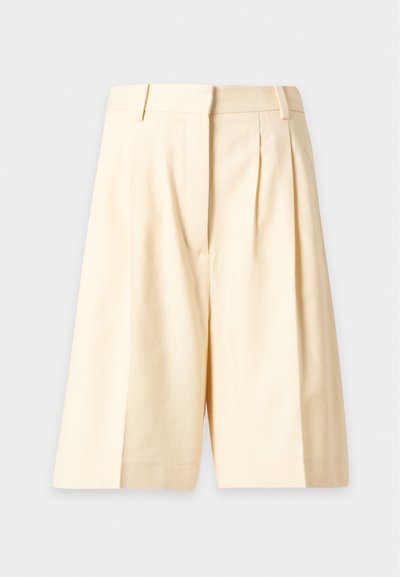 Shorts sur mesure couleur crème, longueur genoux, avec passants de ceinture et détail de couture frontale, présentés sur un fond clair.