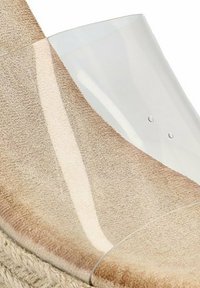 Cuña de esparto beige con parte superior de plástico transparente, que presenta una textura suave y una suela envuelta en yute, destacando un diseño sin costuras.