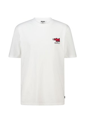 Weißes Baumwoll-T-Shirt mit kurzen Ärmeln. Es zeigt eine rote gestickte Grafik eines Hundes im Bereich der linken Brust und ein Logo darunter.