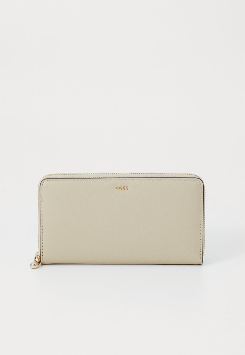 Garšs bežs maciņš, kas izgatavots no gludas ādas, ar rāvējslēdzēju aizdari, ar nelielu metāla akcentu un reljefu zīmola logo priekšpusē.