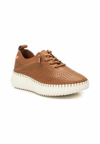 Sneaker in pelle marrone perforata con punta tonda, suola bianca scanalata e lacci. Presenta una linguetta sul tallone per indossarla facilmente.