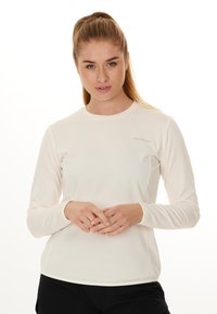 Helles beige Langarm-Sportshirt aus strukturiertem Material, mit rundem Halsausschnitt und kleinem Logo auf der linken Brust.