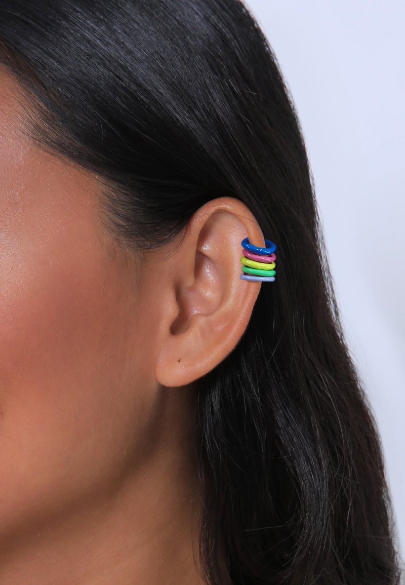 Boucles d'oreilles hoop colorées en bleu, rose, vert et violet empilées sur l'oreille interne. Fabriquées en un matériau brillant avec une texture lisse.