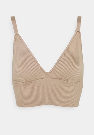 Beige geribbelde gebreide bralette met verstelbare dunne bandjes en een diepe V-halslijn, ontworpen voor comfort en rekbaarheid.