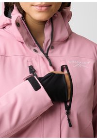 Pink softshell jacket with a hood, featuring black zippers, a zippered chest pocket, and velcro cuff closure. Embroidered logo detail.