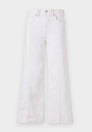 Λευκά παντελόνια φαρδιάς γραμμής φτιαγμένα από τζιν, με ορατές ραφές, κλείσιμο με κουμπί και μπροστινές τσέπες. Το ύφασμα έχει ελάχιστη υφή.