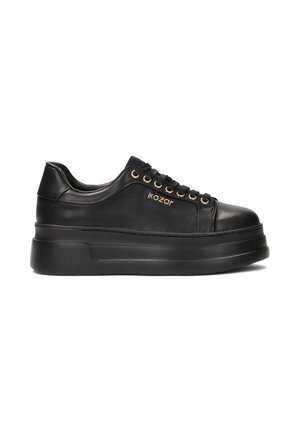 Black platform sneakers featuring smooth leather, gold eyelets, and a round toe design. The brand name "kazar" is embossed on the side.