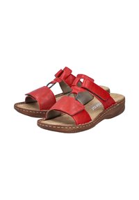 Sandales en cuir rouge avec orteils et talons ouverts, comprenant deux larges brides, des boucles décoratives et des semelles contournées brunes avec des détails de couture.
