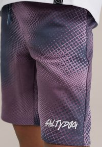 Fialové a tmavosivé plavky sú posiate bodkovaným vzorom a obsahujú názov značky "SALTYDOG" v bielej skripte na dolnej ľavej strane.