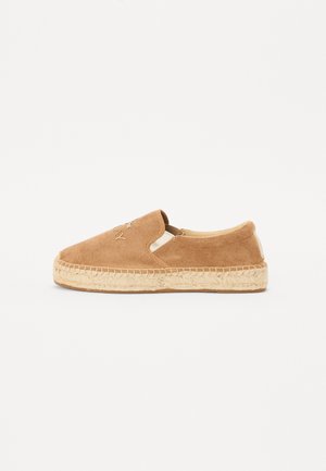 Barna velúr slip-on espadrille juta talppal, rugalmas oldalsó panelekkel és diszkrét márkajelzéssel a lábujj területén.