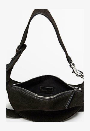 Czarna zamszowa torba na ramię o gładkiej fakturze, z główną komorą na zamek oraz metalowym zatrzaskiem do regulowanego paska.