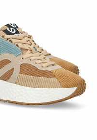 Sneakers con tomaia in corduroy testurizzato nei colori beige, marrone e blu. Suola intermedia texturizzata bianca e suola in gomma color caramello con motivi circolari.