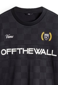 Mustat ruudulliset lyhythihaiset paidat, jotka on valmistettu pehmeästä kankaasta. Ominaisuuksia ovat pyöreä kaula-aukko, valkoinen "OFFTHEWALL" -teksti ja Vans-logo kultaisella laakerilla.