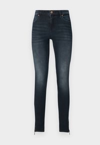 Skinny dark blue jeans made of denim, featuring a button closure, front pockets, and zippers at the ankle. Smooth texture with subtle fading.