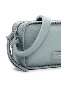 Borsa a tracolla in pelle testurizzata blu chiaro con cuciture visibili, zip argentata e targhetta in metallo con logo sul davanti.