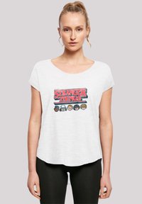 White relaxed-fit t-shirt featuring a graphic design of "Stranger Things" with illustrated characters, round neckline, and short sleeves.