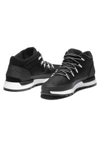 Czarne tekstylne buty o wysokim kroju i szarych akcentach; posiadają grube sznurówki, wyściełany kołnierz oraz białą podeszwę.