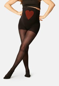 Collant neri a vita alta con un design a cuore rosso testurizzato sul davanti, finitura senza cuciture e sezioni delle gambe semi-opache.