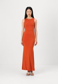 Robe maxi orange ajustée sans manches en tissu doux, avec un col rond et une texture lisse, dotée d'une fente à l'ourlet.