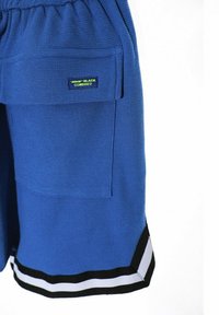 Pantalones cortos azul texturizados con cintura elástica, bolsillos laterales y acentos a rayas en blanco y negro en el dobladillo. Etiqueta de la marca en el bolsillo.