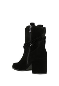 Černé semišové kotníkové boty se zipem na boku, silným podpatkem, dekoračním detailem na šňůrce a hladkým povrchem. Kulatá špička a robustní konstrukce.