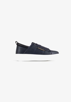 Sneaker in pelle blu navy con suola in gomma bianca, caratterizzato da una punta rotonda, lacci, accentuazione del logo color cammello e una linguetta sul tallone di colore nero a contrasto.