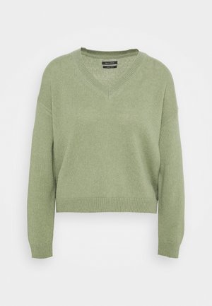 Pull en maille vert clair à col en V avec manches longues et poignets et ourlet côtelés sur fond uni.