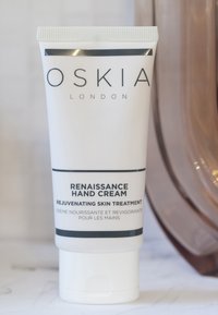 Tubetto bianco di OSKIA Renaissance Hand Cream con scritte nere, caratterizzato da una consistenza liscia e un tappo a ribalta, etichettato come trattamento per la pelle.