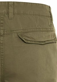 Olivgrüne Cargo-Shorts mit strukturierter Oberfläche, ausgestattet mit einer Gesäßtasche mit Klappe und genähten Details am Bund und den Nähten.
