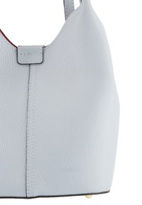 Sac à main en cuir bleu clair avec une texture lisse, des coutures minimales et un logo embossé en bas. Anse de shoulder attachée.