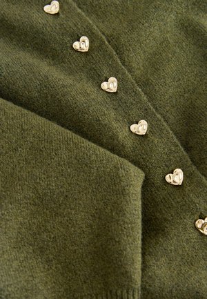 Olivgrüner Pullover aus weichem Material mit strukturiertem Finish, der an der Vorderseite kleine goldene herzförmige Knöpfe für denverschluss aufweist.